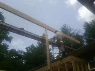 Carpenter setting a ridge beam over a new addition frame — Ice Dam Removal by Roofing Brothers in East Rochester