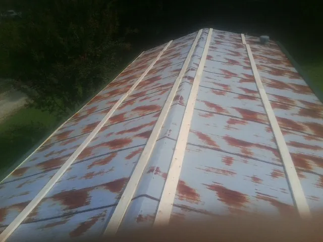 Rusted metal roof panels with new wood purlins before replacement — Storm Damage Roof Repair in East Rochester by Roofing Brothers