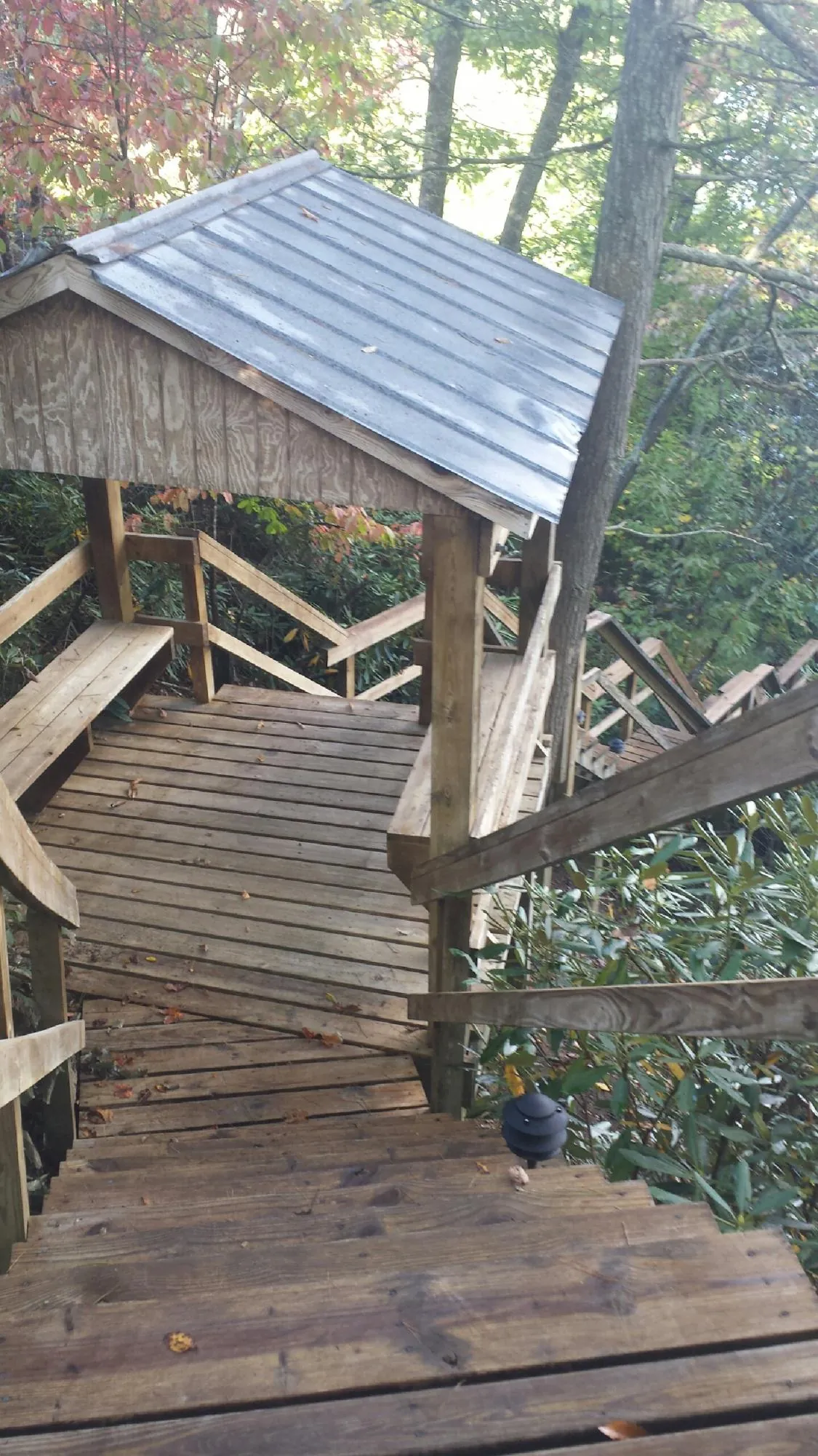 Metal roofed shelter over wooden steps on a wooded walkway — Skylight Repair & Installation work by our crew in East Rochester