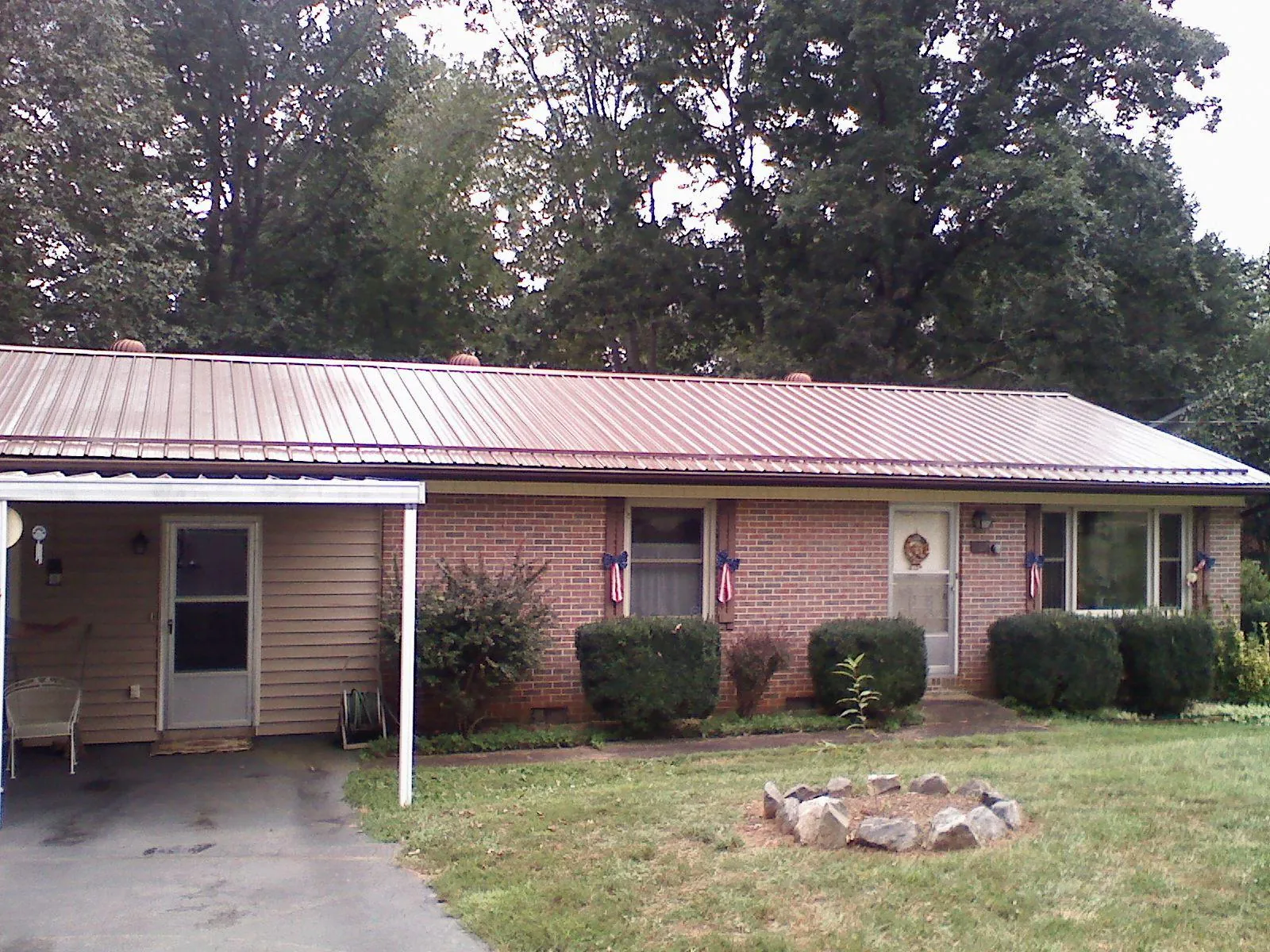 Bronze metal roof and carport on a brick ranch home — Roof Repair work by our crew in East Rochester